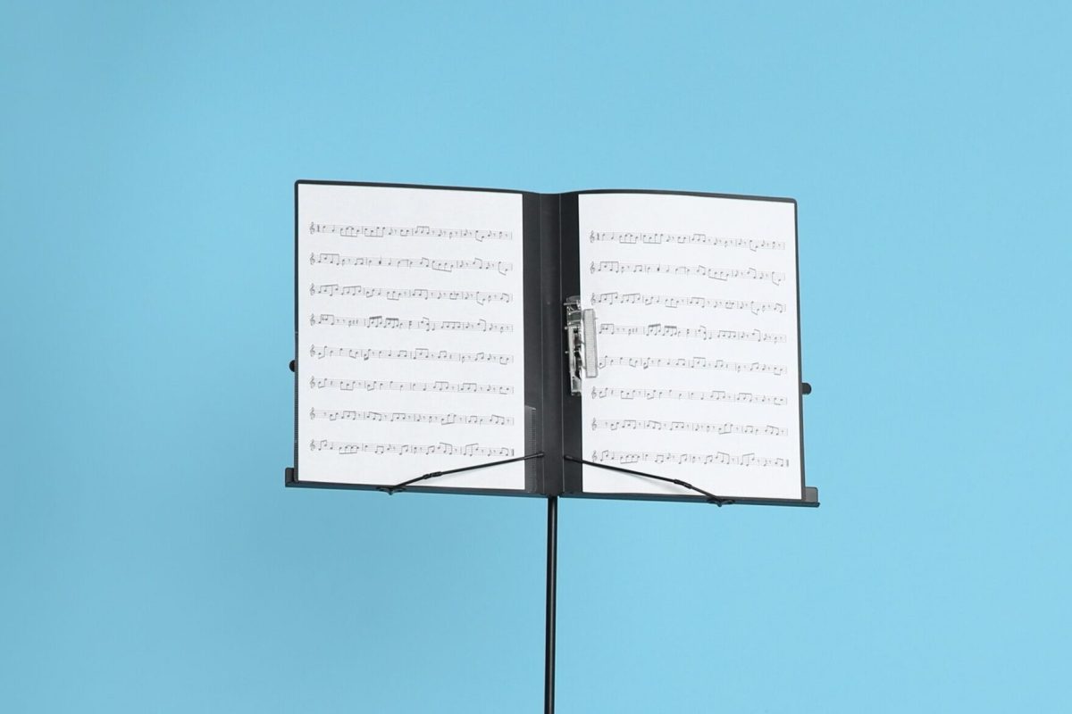 Note stand with music sheets on color background. Space for text
